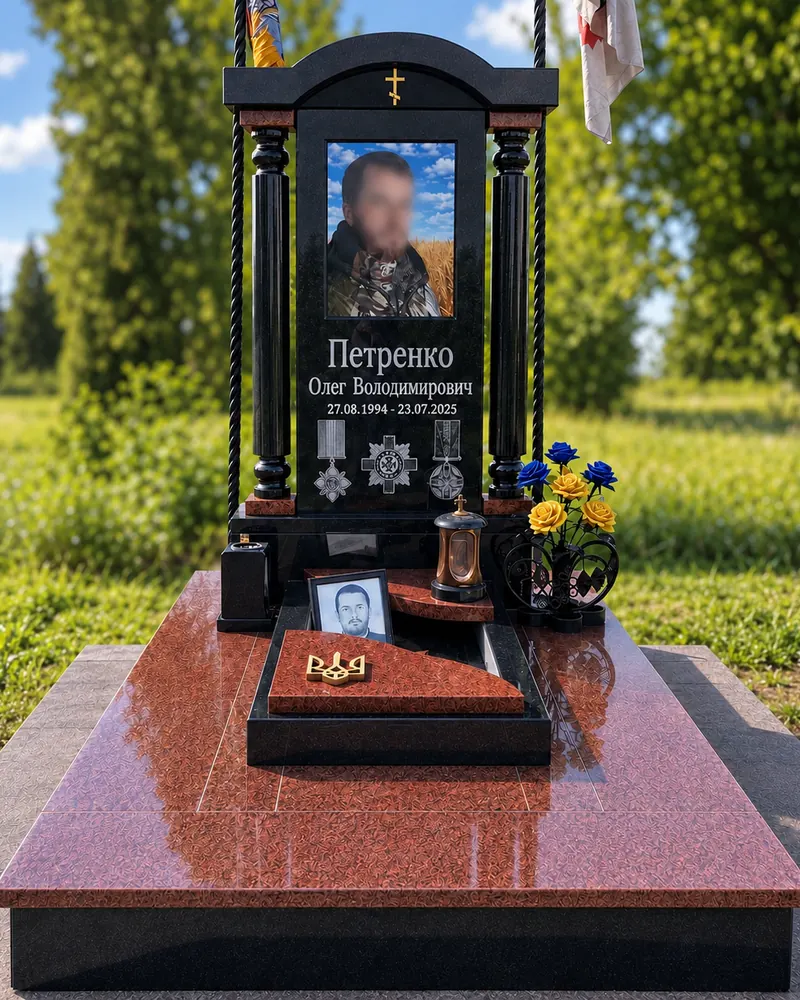 Пам’ятник військовому В-16 — чорна стела з точеними колонами, портретом і нагородами на червоному цоколі